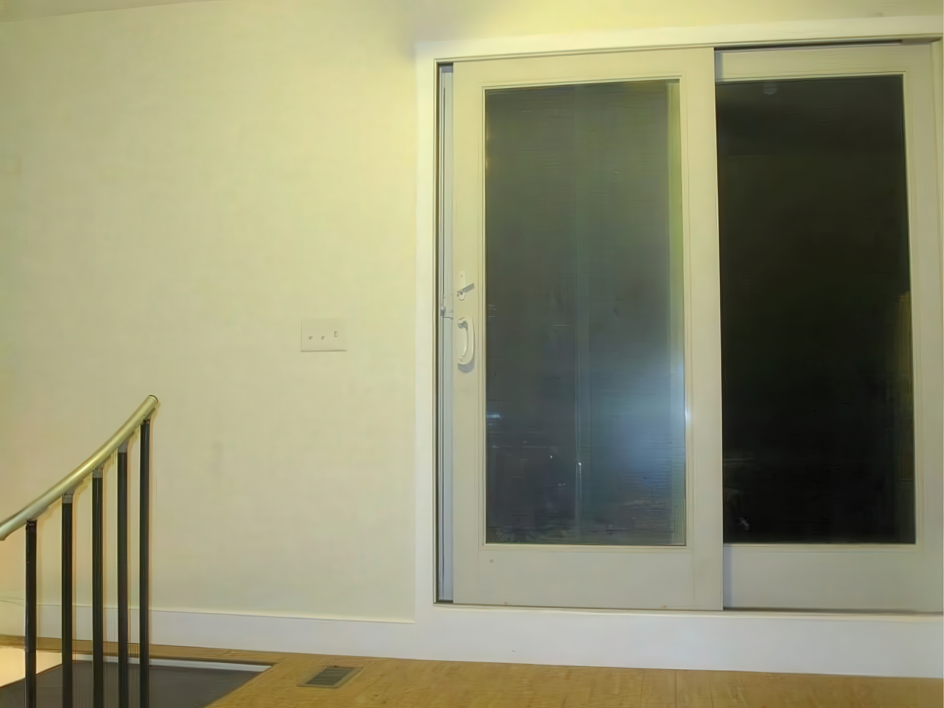 New sliding glass door installation with spiral staircase access in Philadelphia rowhome