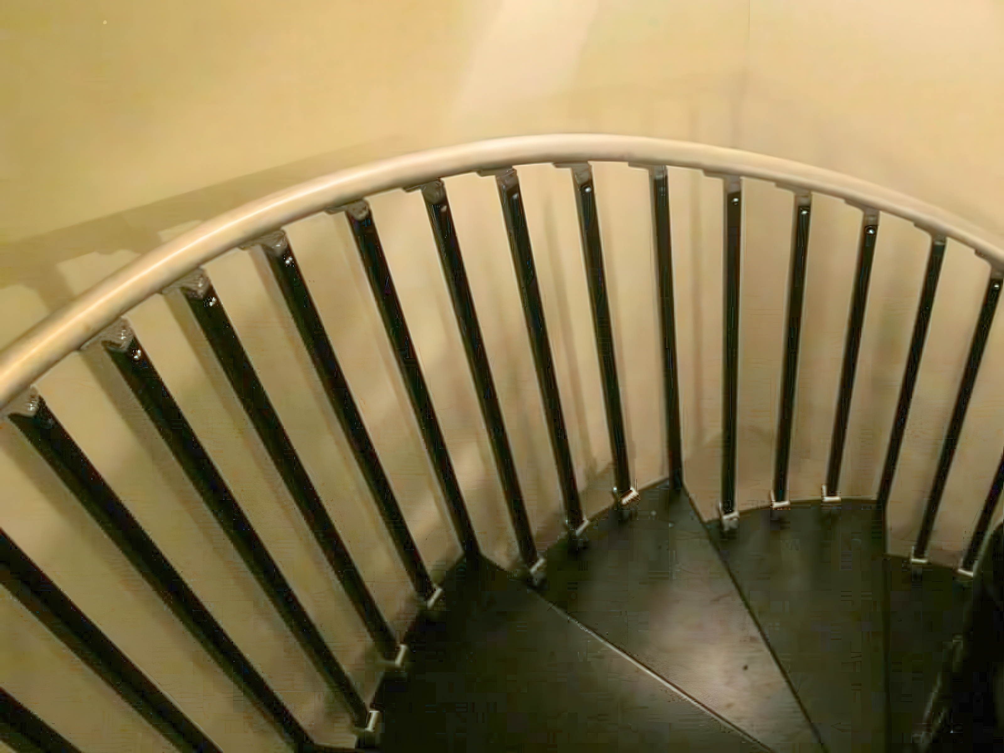 Custom metal spiral staircase with curved railing in Philadelphia rowhome