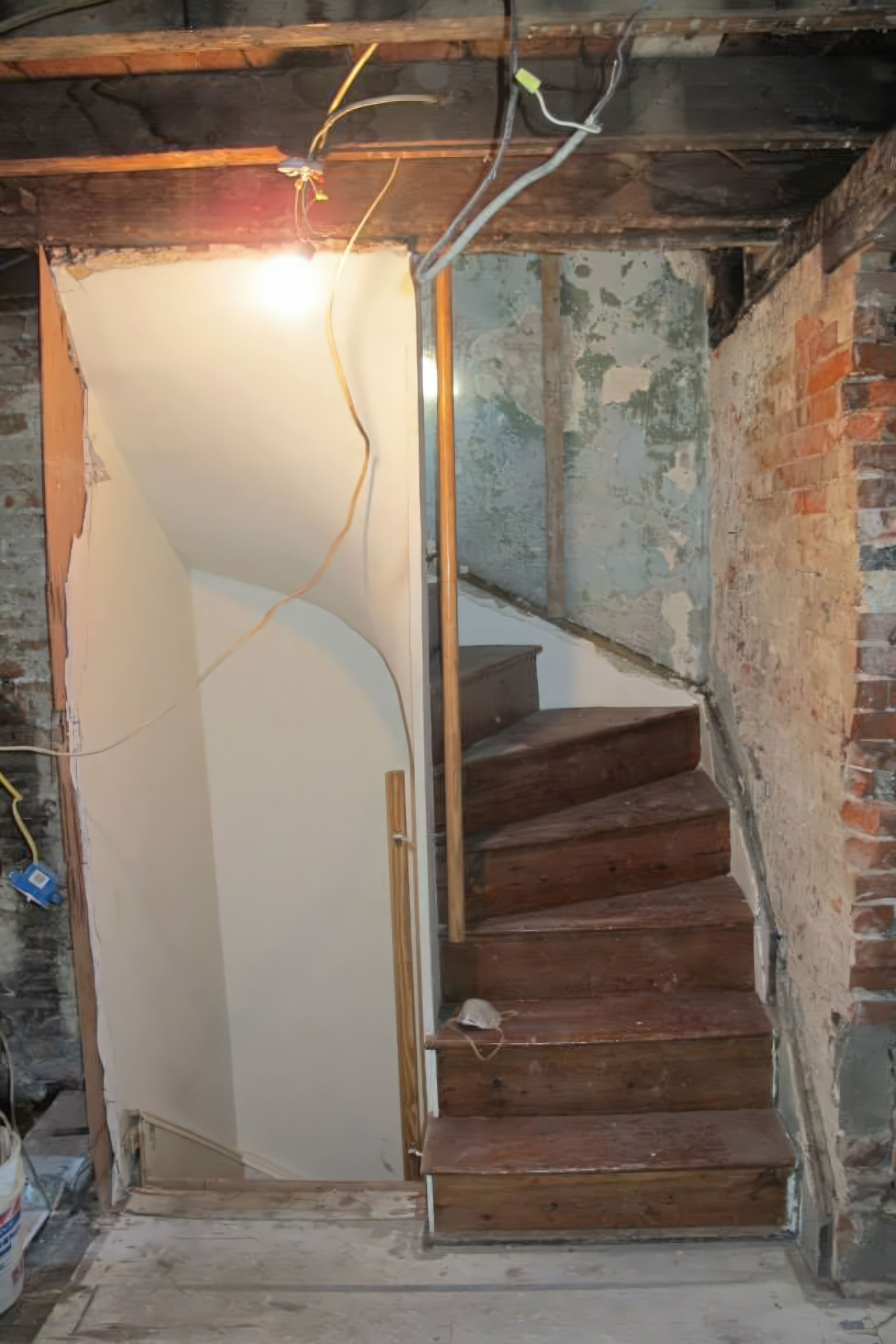 Staircase area during demo with exposed brick walls