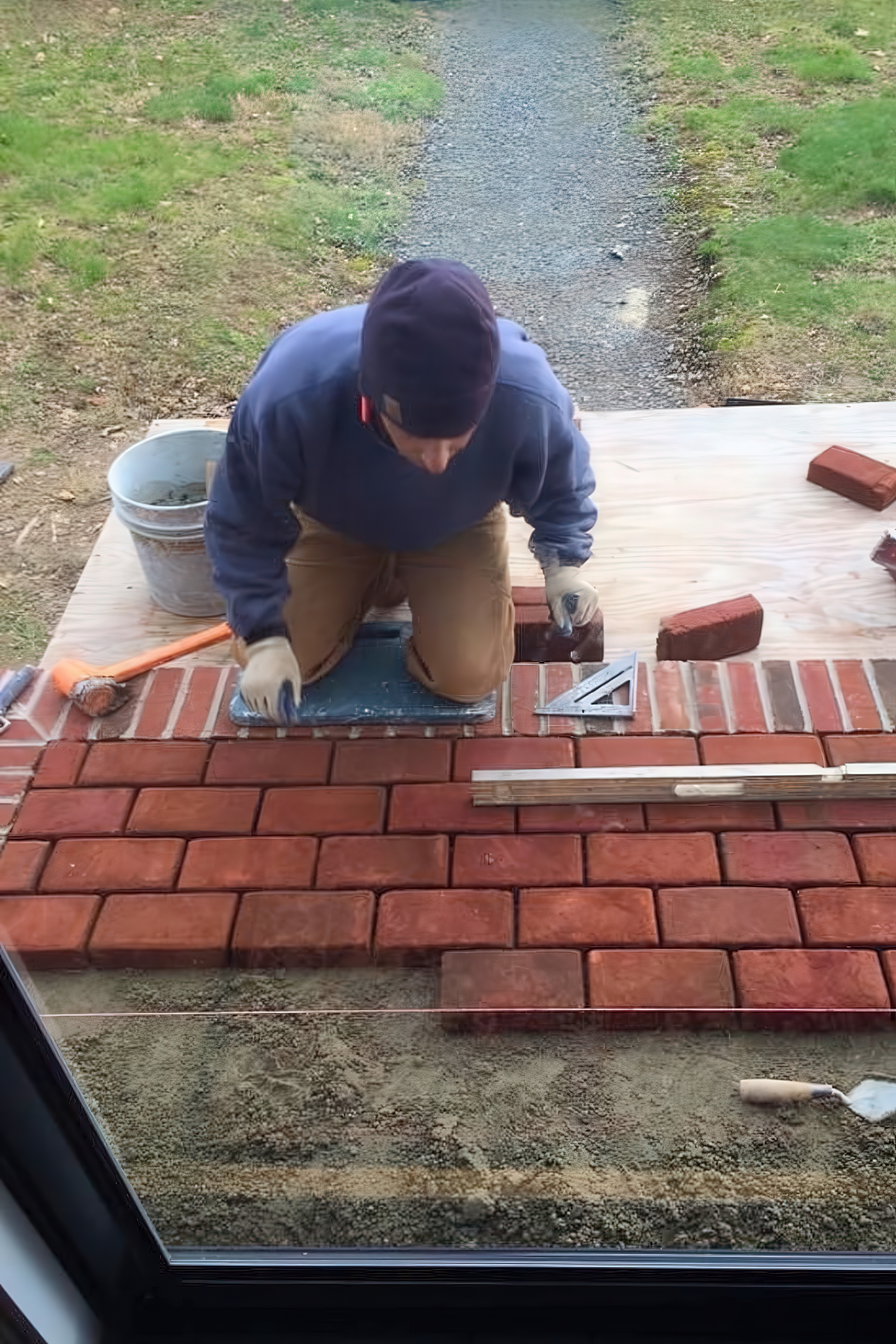 Scott laying brick from above, showing craftsmanship and detail work