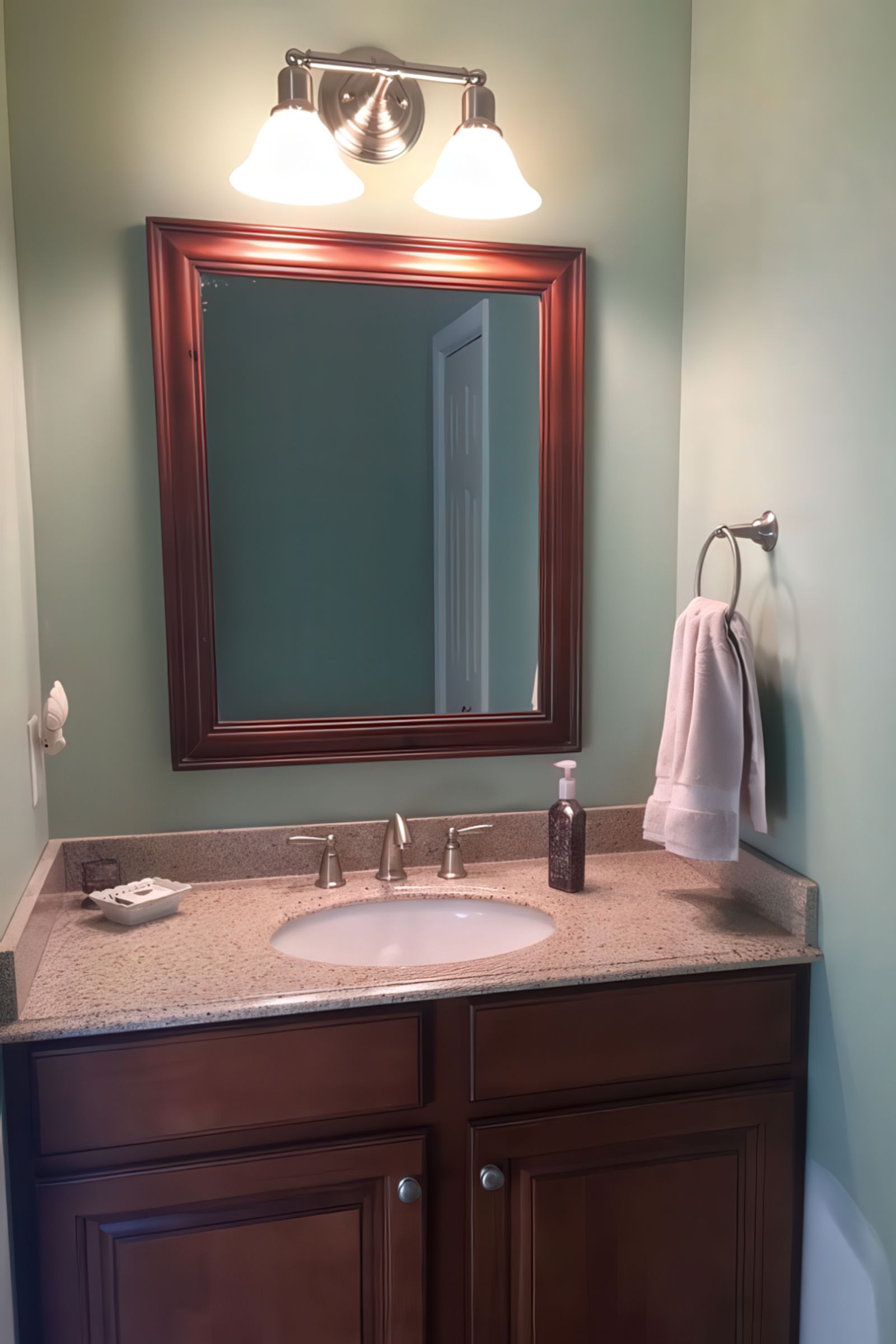Powder room renovation with dark wood vanity and granite countertop