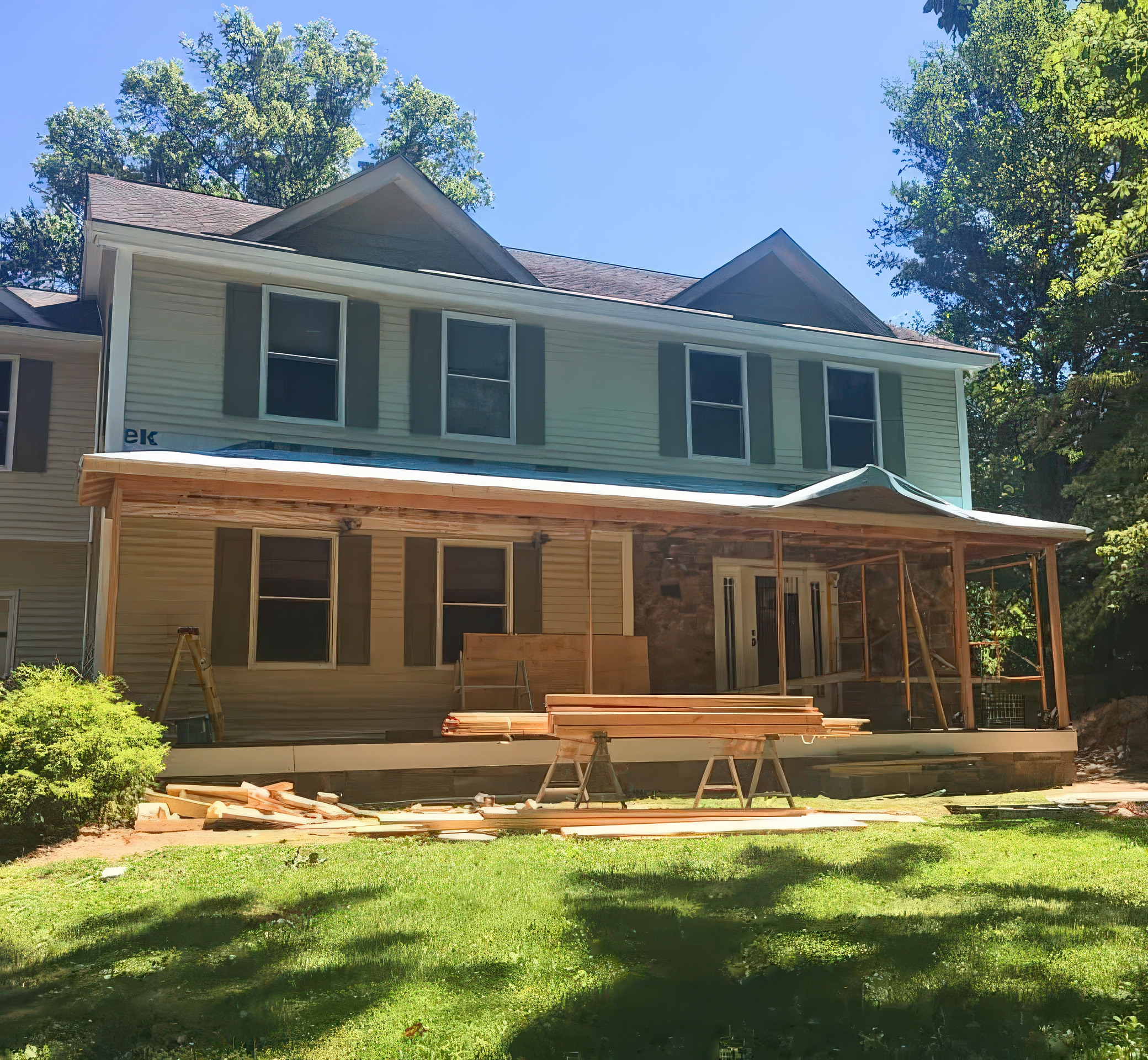 Wide front view during porch framing with lumber and roof structure going up