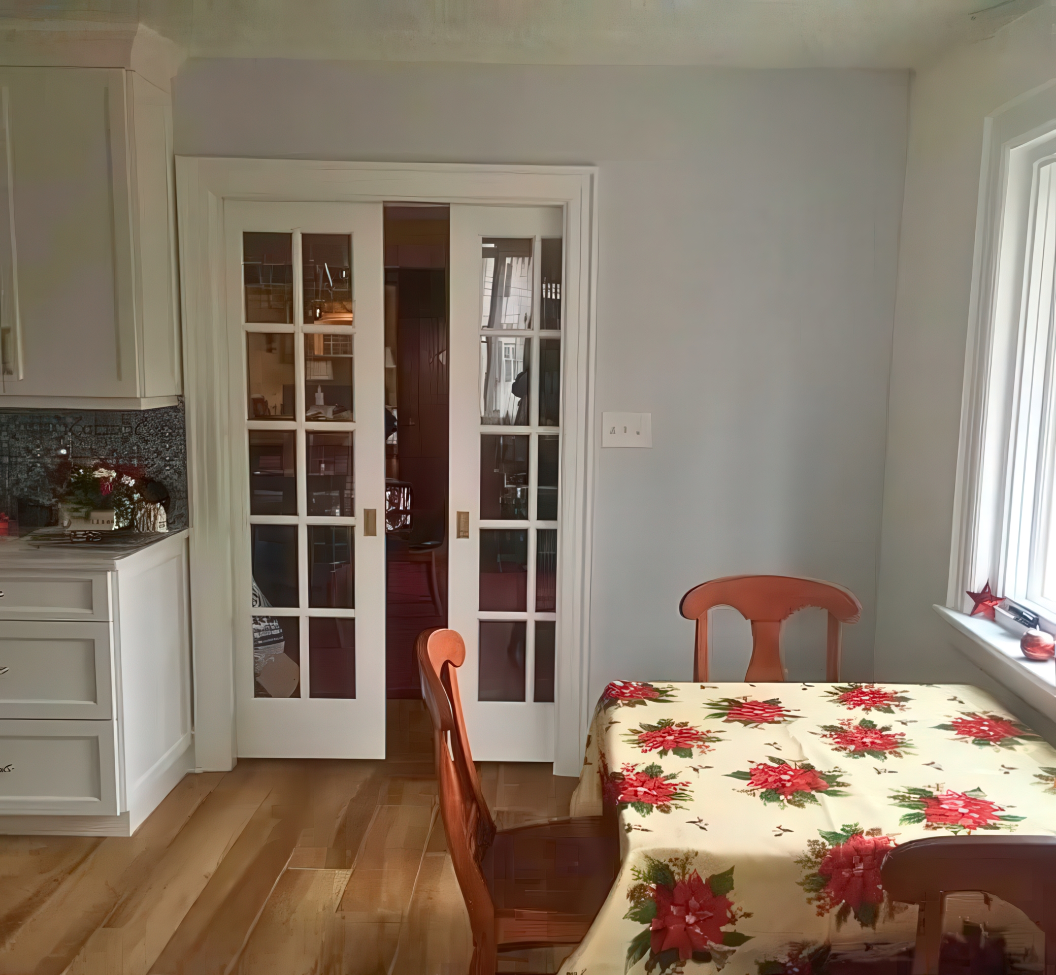 Wide view of dining area with French doors and kitchen counter visible
