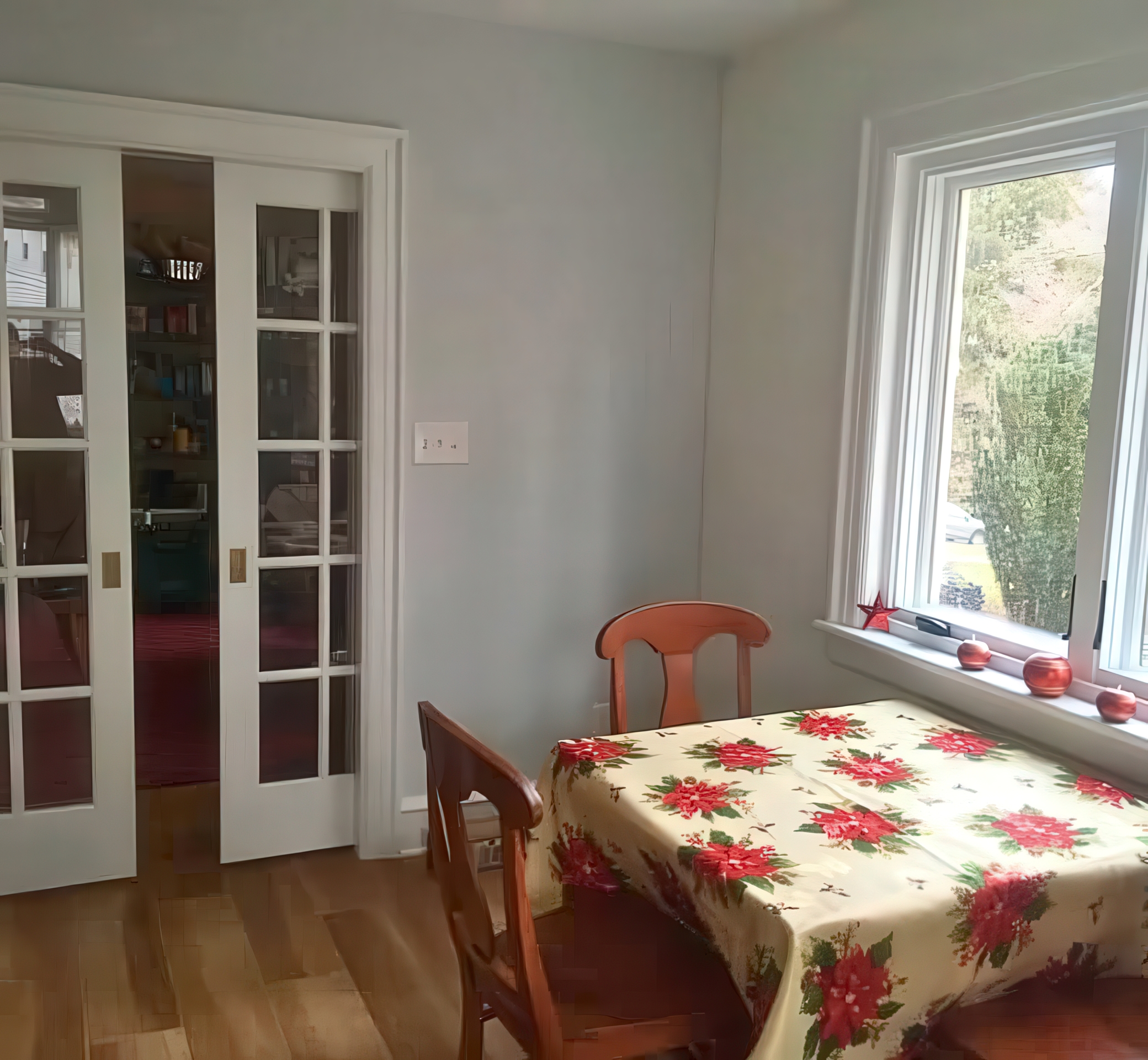 Dining area with French glass pocket doors, window, and hardwood floors
